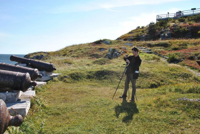 MA student Jake De La Plante photographing cannons along a coastal landscape