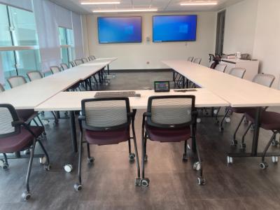 photo of seminar room including tables arranged in a u-shape with chairs around the outside