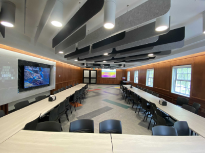 photo of a large multipurpose meeting space showing tables arranged in a u-shape with chairs around