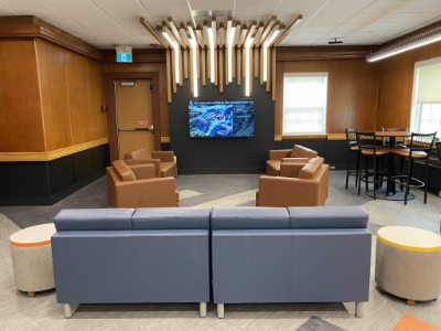 photo of an informal student space with comfortable couches, chairs, and a table