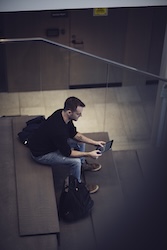 a student on a bench reviewing digital content on a tablet