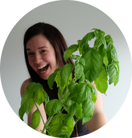 Emily Bland holding growing basil plant.