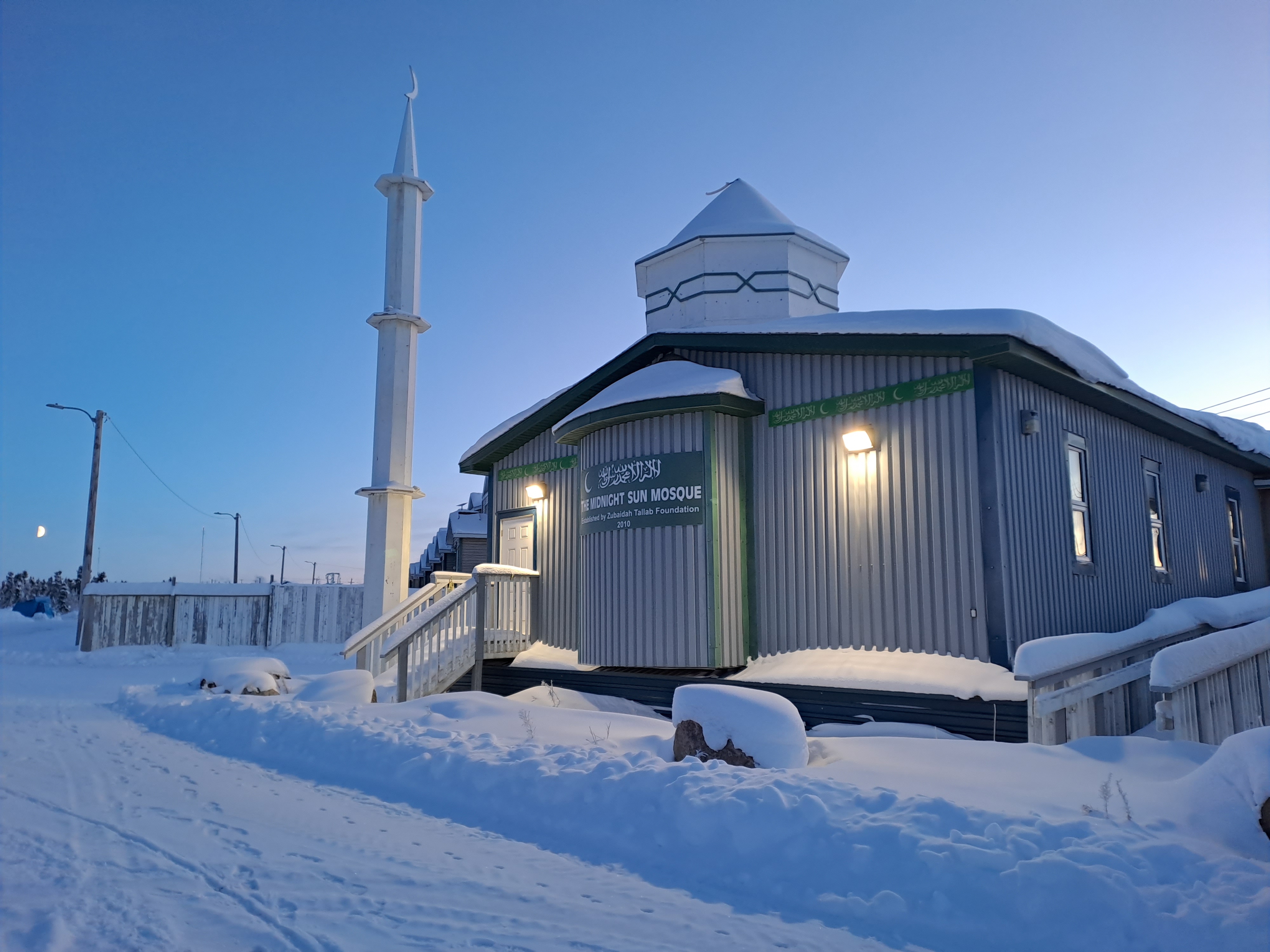 A small mosque in a snow-covered fied.