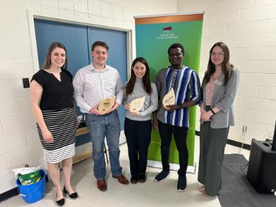 CSE staff standing with 3 incubator graduates holding their new plaques